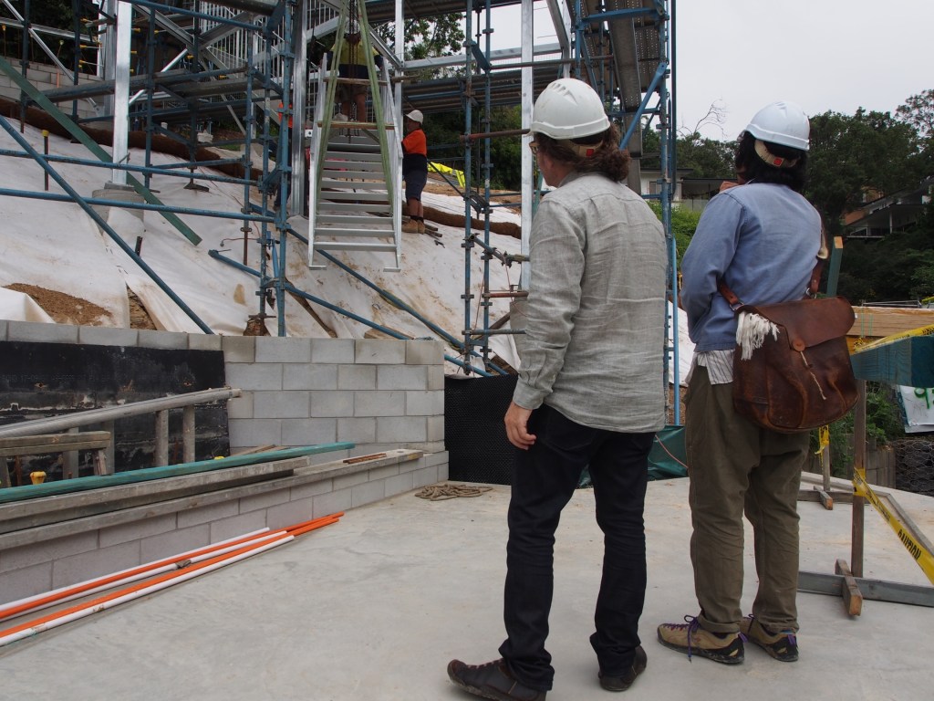 Architects nervously watching the final piece of stair being coaxed into place.