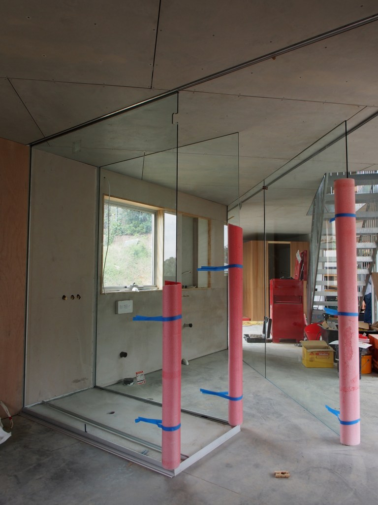 The glass bathroom from the bedroom side. Shower in foreground.